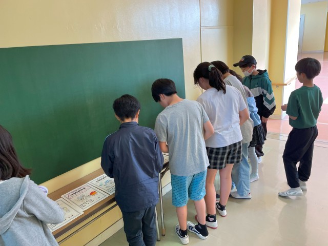 春川場実行委員　表紙に採用する絵を真剣に選んでいる様子