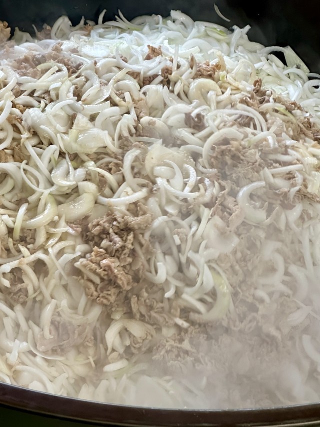 豚肉と玉ねぎを炒めている様子。玉ねぎは、38キロ使っています。