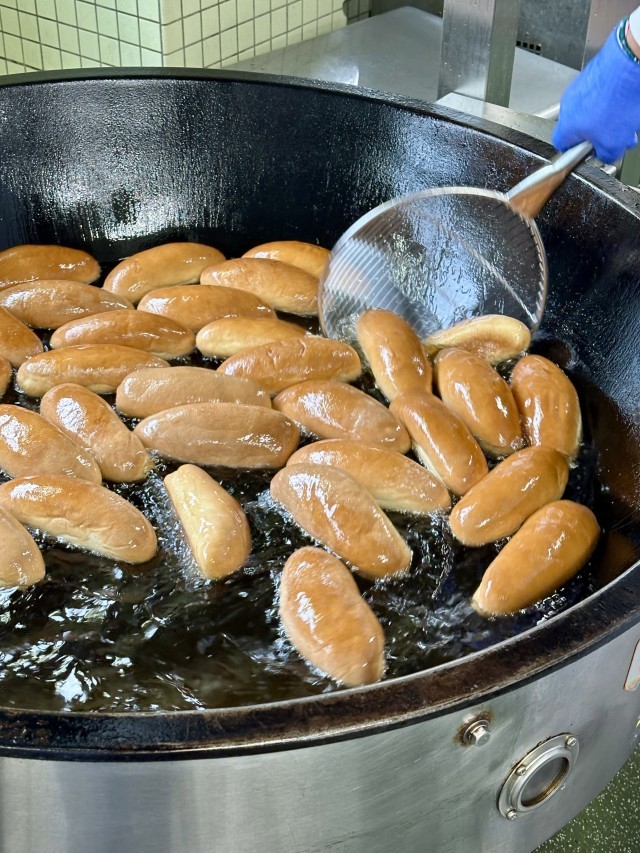 コッペぱんを油で揚げている様子。