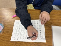 受付用紙に参加者数を記録する部員の手元