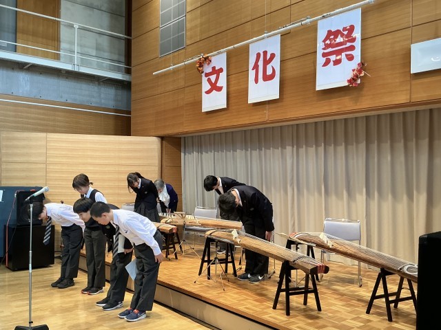 演奏が終わり舞台でお辞儀をする部員と指導員