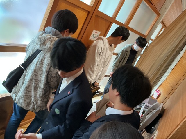 舞台袖で箏を片付ける2年生と、それを手伝う3年生