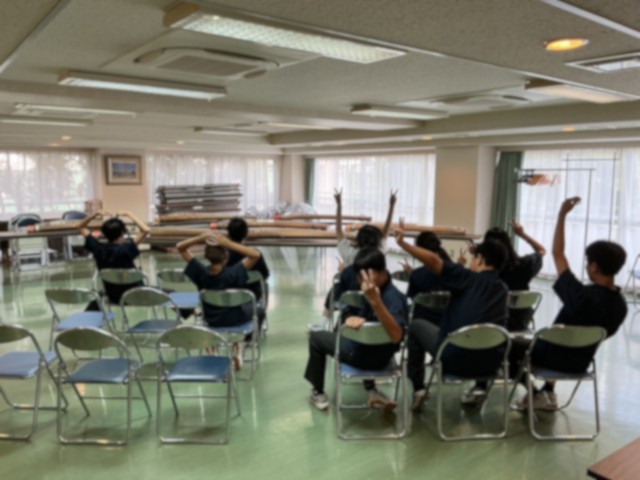 演奏会に向けてお試しの設営をしたミーティングルームでポーズをとる部員たち